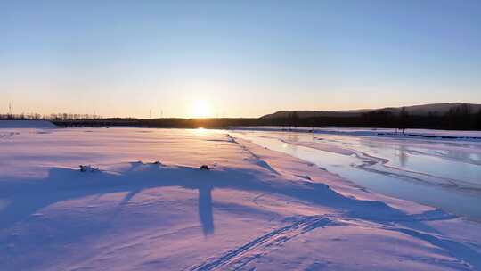 夕阳下内蒙古北方不冻河平静水面雪雾袅袅