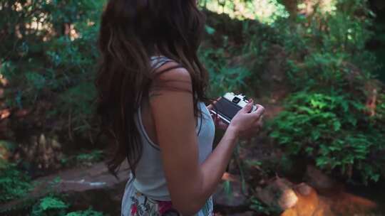 户外林中用相机拍照的女子视频素材模板下载