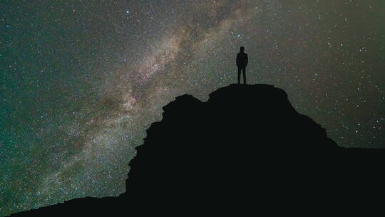 一个人站在山顶上仰望星空