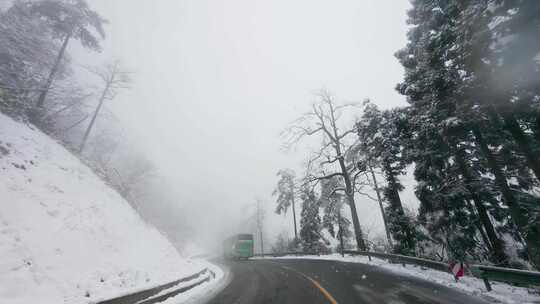 山间雪景盘旋公路：行车记录前方大巴车行驶