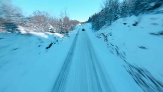 FPV航拍汽车行驶在冰雪森林公路上雪景