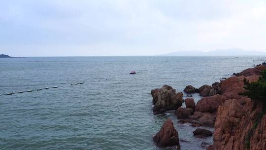 实拍青岛海岸线晚霞海水礁石与游客乘船视频