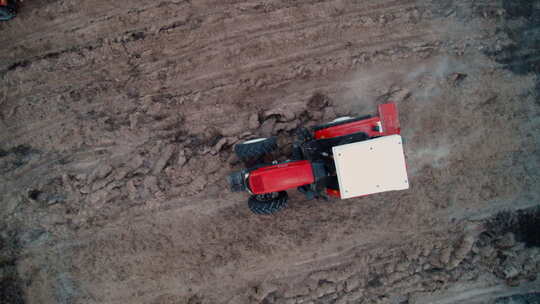 柬埔寨航拍红色拖拉机在泥土地上作业