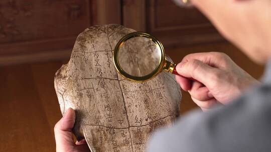 考古人手拿放大镜甲骨文远古文化考古研究