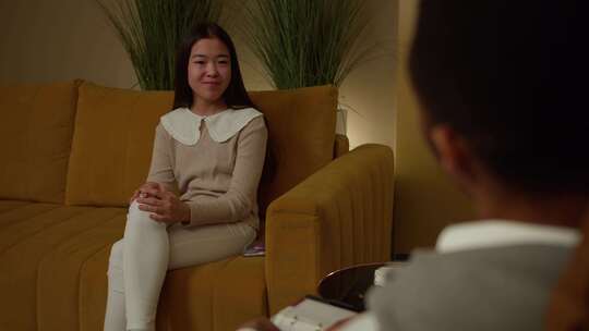 一个亚洲女孩和心理学家在心理治疗中谈论精神问题