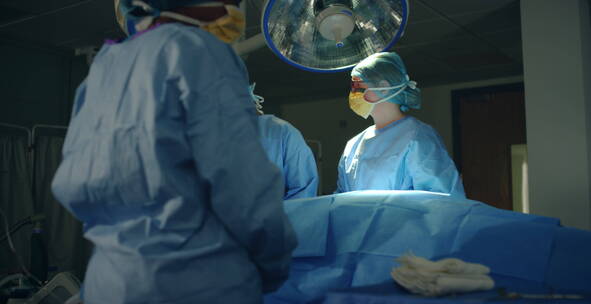 助手将手术器械递给外科医生