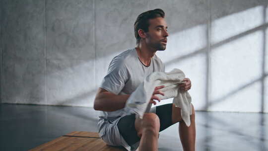 汗流浃背的运动员在疲劳的举重运动员休息时