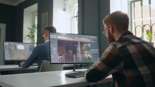 游戏开发部门的人坐在桌旁，用强大的电脑制作3D图形