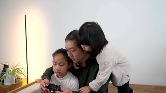 父亲带着两个女儿玩电子游戏视频素材模板下载