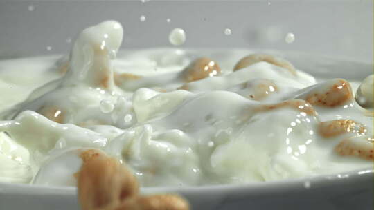 玉米片落入流动的牛奶中
