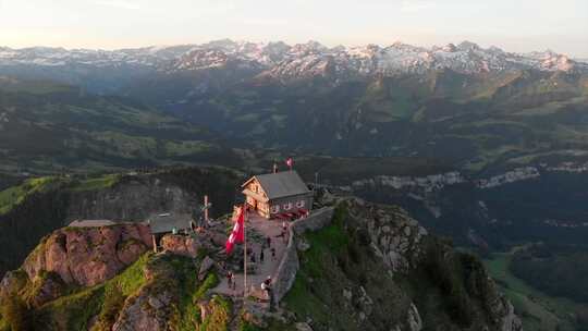 清晨无人驾驶飞机可以看到瑞士山顶，山上有餐厅和第一批客人。瑞士国旗