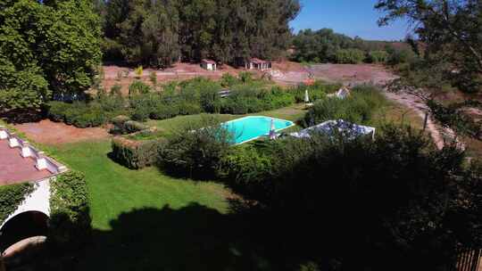 蓝色的地下游泳池坐落在经典葡萄牙庄园后面修剪整齐的草坪花园区域