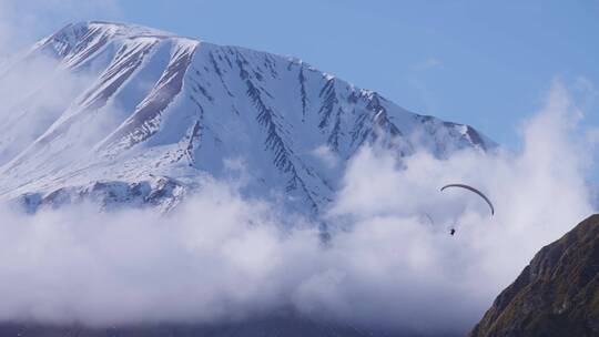 雪山间滑滑翔伞的人视频素材模板下载