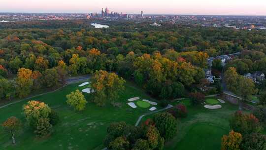 秋天日落时的美国高尔夫球场。远处的费城天际线。