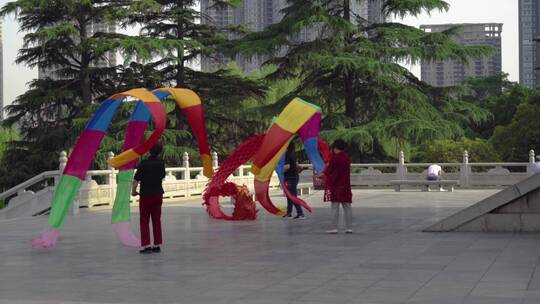 户外广场多人舞动彩色绸带