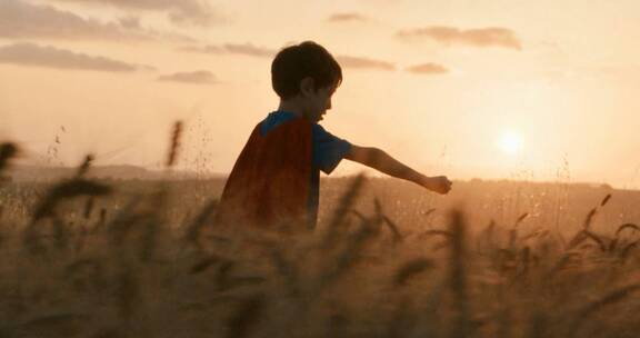小男孩奔跑在麦田里。