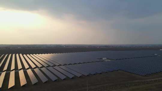 早春日落时，无人机观察太阳能农场的大型太阳能电池板视频素材模板下载