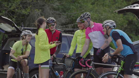 一群骑自行车的人一起在手机上看照片。完全发布用于商业用途。视频素材模板下载