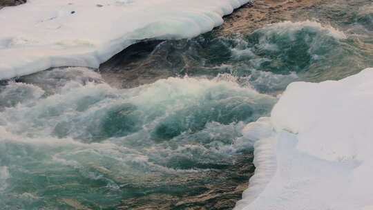 冬季冰雪覆盖的山间河流湍急流淌