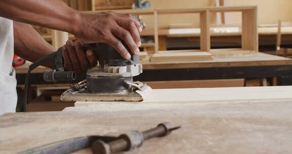 木匠用电动研磨机研磨木板