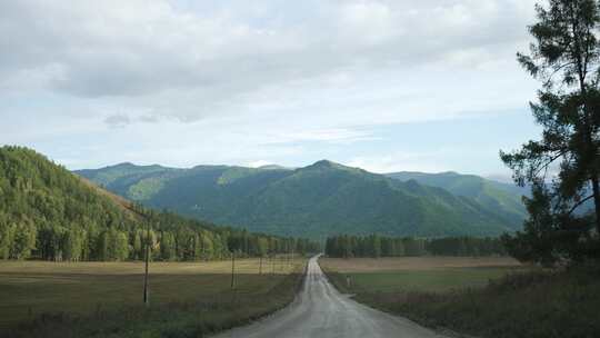 风景优美的乡村公路通往远处的山脉，在阴天