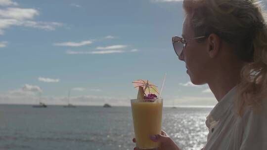 女人在海边喝饮料