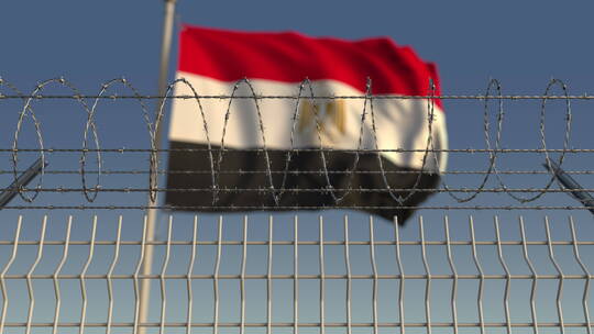 带刺铁丝网后模糊的埃及国旗