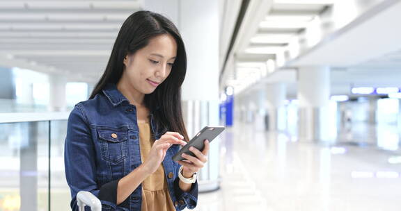 女人在机场玩手机等待登机