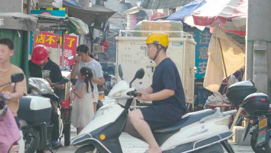 古巷街道前的马路：车流，电瓶车，行人