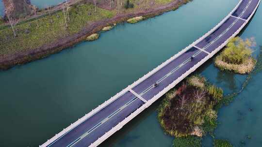 高空视角俯拍水上公路行驶的摩托车