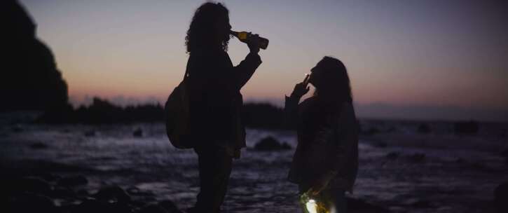 男人和女人在海滩上喝啤酒和抽烟