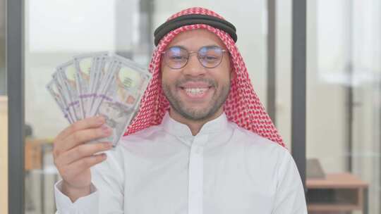 年轻的阿拉伯男人展示金钱的肖像视频素材模板下载