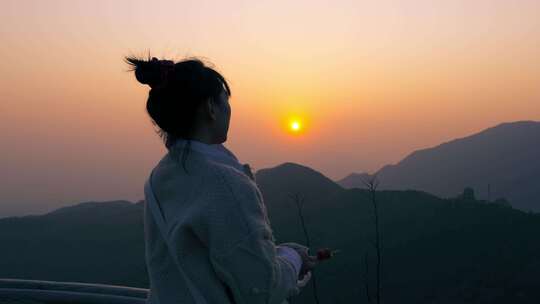 女孩在山顶看日落