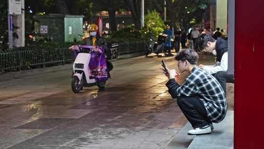 马路边吃快餐看手机年轻人视频素材模板下载
