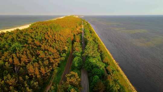 鸟瞰汽车在海岸公路上行驶，穿过蓝海附近的