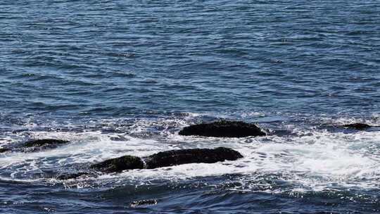 晴朗海面海浪拍打礁石蓝色海洋浪花慢镜头