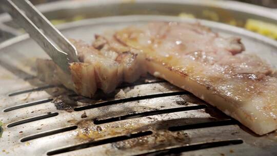 4k慢动作韩式烤肉肉在铁板上烤制滚油拨动