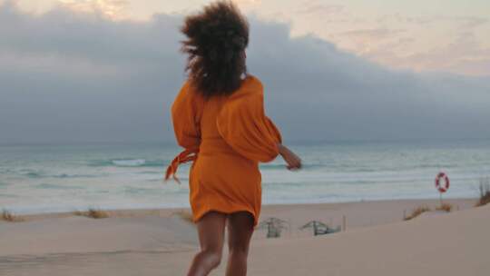女人在沙滩上快乐的奔跑