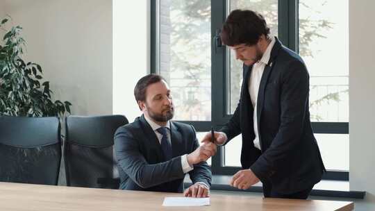 两个男人在会议室签字握手