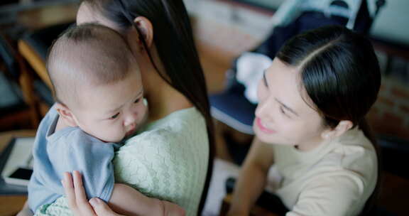 两个年轻的亚洲女人在咖啡馆里开心地和一个