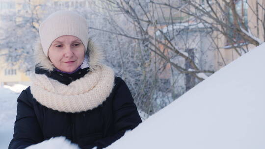 女人从车里除雪