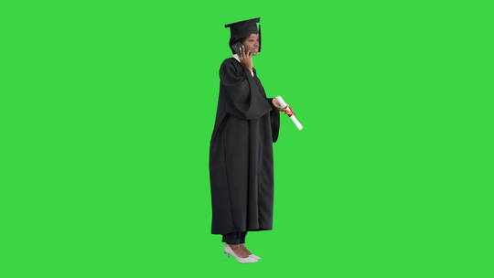 穿着毕业礼服的女学生在绿幕下打电话