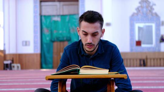 清真寺背诵古兰经的青年