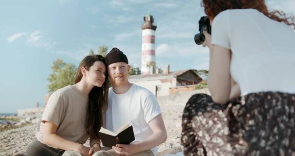 摄影师在海滩上给一对情侣拍照