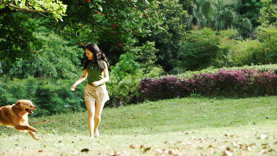 美女和宠物狗金毛犬在公园里玩耍奔跑慢镜头