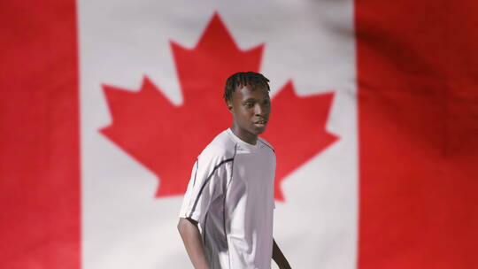 足球运动员在加拿大国旗前欢呼跳跃