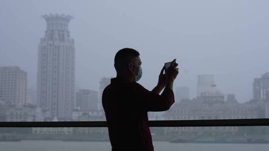 黄浦江畔拍照的男人
