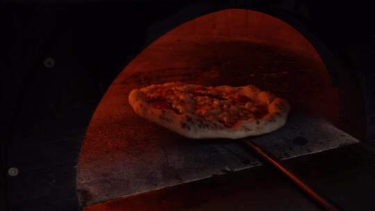 意大利披萨烤箱里烤披萨，周围有火，慢动作