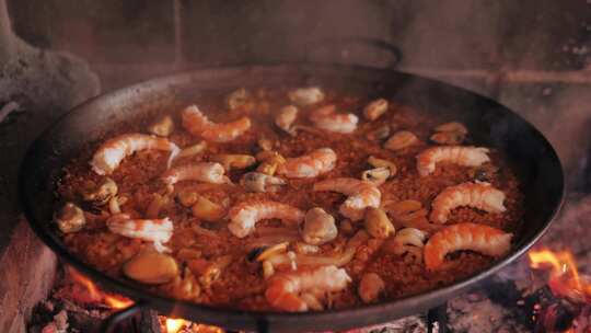 在炉子上烹饪传统西班牙海鲜饭