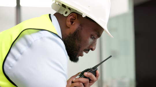建筑商、承包商和技术人员在管理时用无线电发射器对讲机交谈